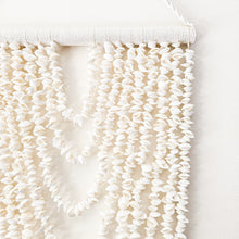 Coastal shell wall hanging featuring 9 cascading strands, designed to bring natural texture and relaxed boho style into your home. Measuring 105cm long x 40cm wide, this lightweight statement piece is perfect for styling in living rooms, bedrooms or entryways.