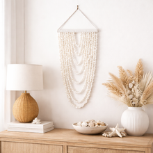 Coastal shell wall hanging featuring 9 cascading strands, designed to bring natural texture and relaxed boho style into your home. Measuring 105cm long x 40cm wide, this lightweight statement piece is perfect for styling in living rooms, bedrooms or entryways.