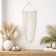 Coastal shell wall hanging featuring 9 cascading strands, designed to bring natural texture and relaxed boho style into your home. Measuring 105cm long x 40cm wide, this lightweight statement piece is perfect for styling in living rooms, bedrooms or entryways.