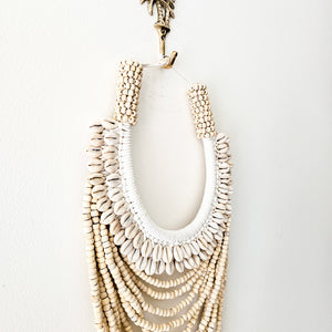 Natural cowrie shell and wood bead wall decor necklace. Coastal Bohemain inspired home interior style. Natural handcrafted home decor.