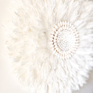 Soft white Feather and shell wall juju art. Natural wall hanging for a Coastal boho, Bohemian Home aesthetic. Wall decor art with soft textures and shell design in the center. Large unique wall decor.
White Feather Juju. 
