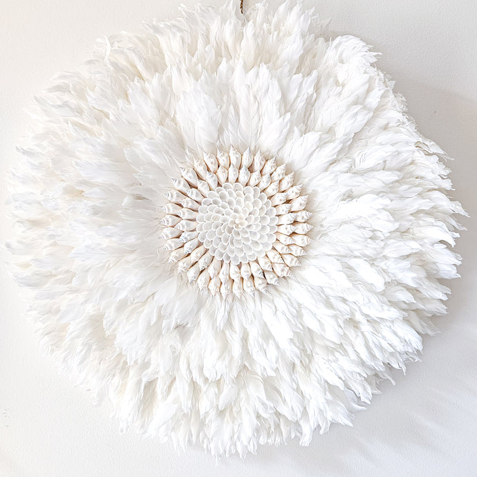 Soft white Feather and shell wall juju art. Natural wall hanging for a Coastal boho, Bohemian Home aesthetic. Wall decor art with soft textures and shell design in the center. Large unique wall decor.
White Feather Juju. 