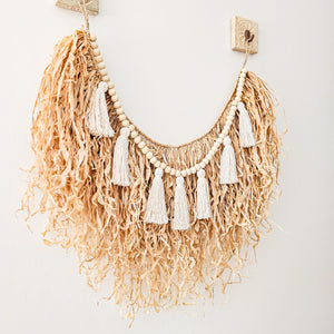 Natural straw, Raffia hanging with wood beaded garland of cotton tassels. Coastal Bohemain, boho inspired home. Coastal boho interior style wall hangings. Natural wall art. Natural earrhy organic materials. 