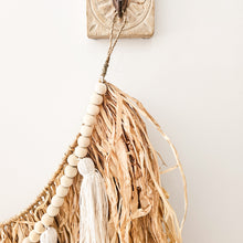 Natural straw, Raffia hanging with wood beaded garland of cotton tassels. Coastal Bohemain, boho inspired home. Coastal boho interior style wall hangings. Natural wall art. Natural earrhy organic materials. 